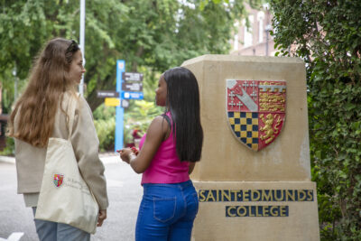 Two female students walking into College