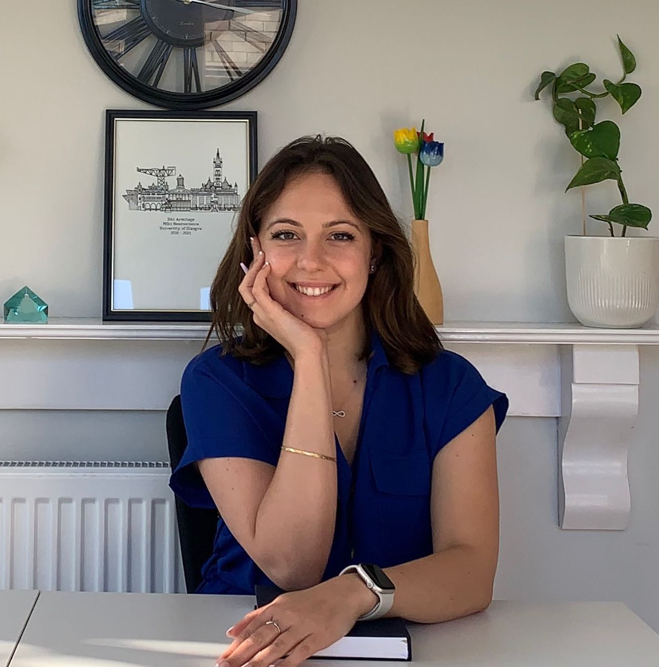 Headshot of Bianca Armitage smiling, sitting at a desk.