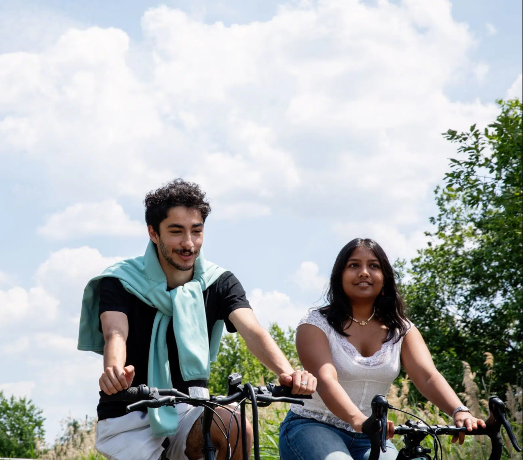 Two University of Cambridge students cycling near the West Café.